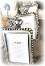 Pieni romanttinen Kruunu-valokuvakehys, metallia ja koristekiviä jonossa pöydällä. Kruunu jokaisen kehyksen yläosassa. La Petite Provence