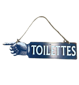 Kahdensuuntainen vessan kyltti tekstillä Toilettes ja kädellä joka näyttää vessan suunnan, ripustusnyöri luonnonväristä narua ja kyltin väri tumma sininen valkoisilla 3D-kirjaimilla La Petite Provence