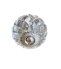 Pyöreä kristallinkirkas lasivedin nuppi hopeanvärisillä metalliosilla, lasinupissa lasisärmiä prässilasimaisesti tehtyinä La Petite Provence