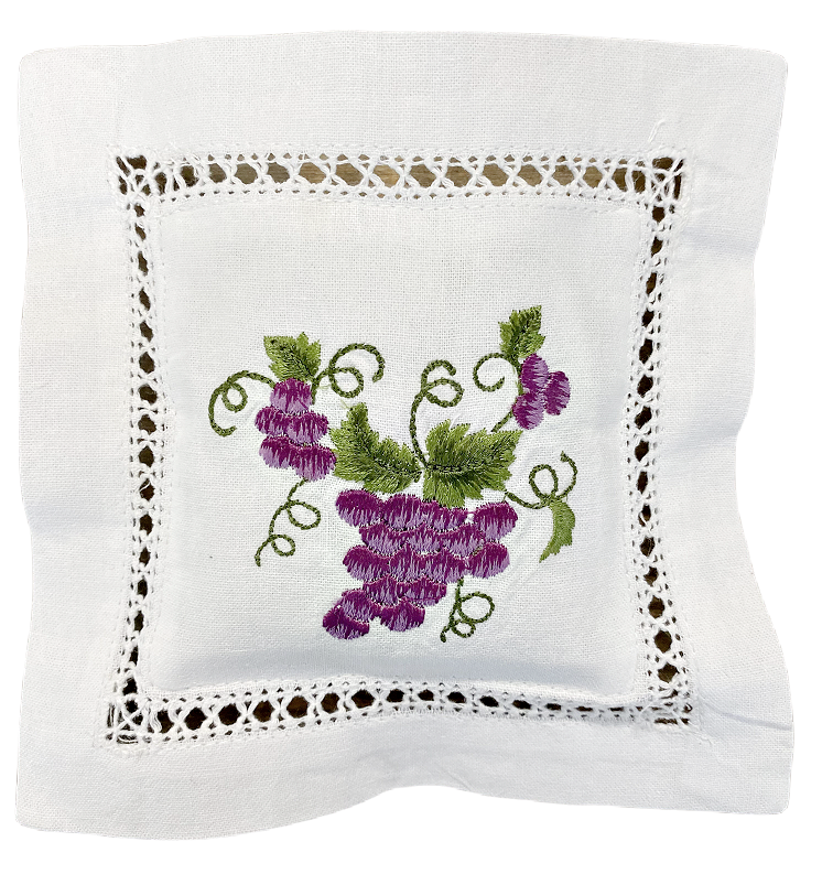 Laventelityyny brodeeratulla viinirypäletertun kuvalla jossa violetteja rypäleitä ja viininlehtiä, valkoinen puuvillatyyny jossa pitsireunaa La Petite Provence