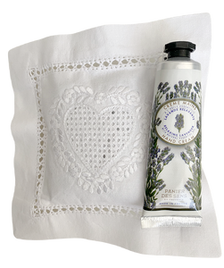 Valkoinen laventelityyny jossa brodeerattu sydän sekä pieni laventelikäsirasva jossa laventelinkuvia ja musta korkki La Petite Provence